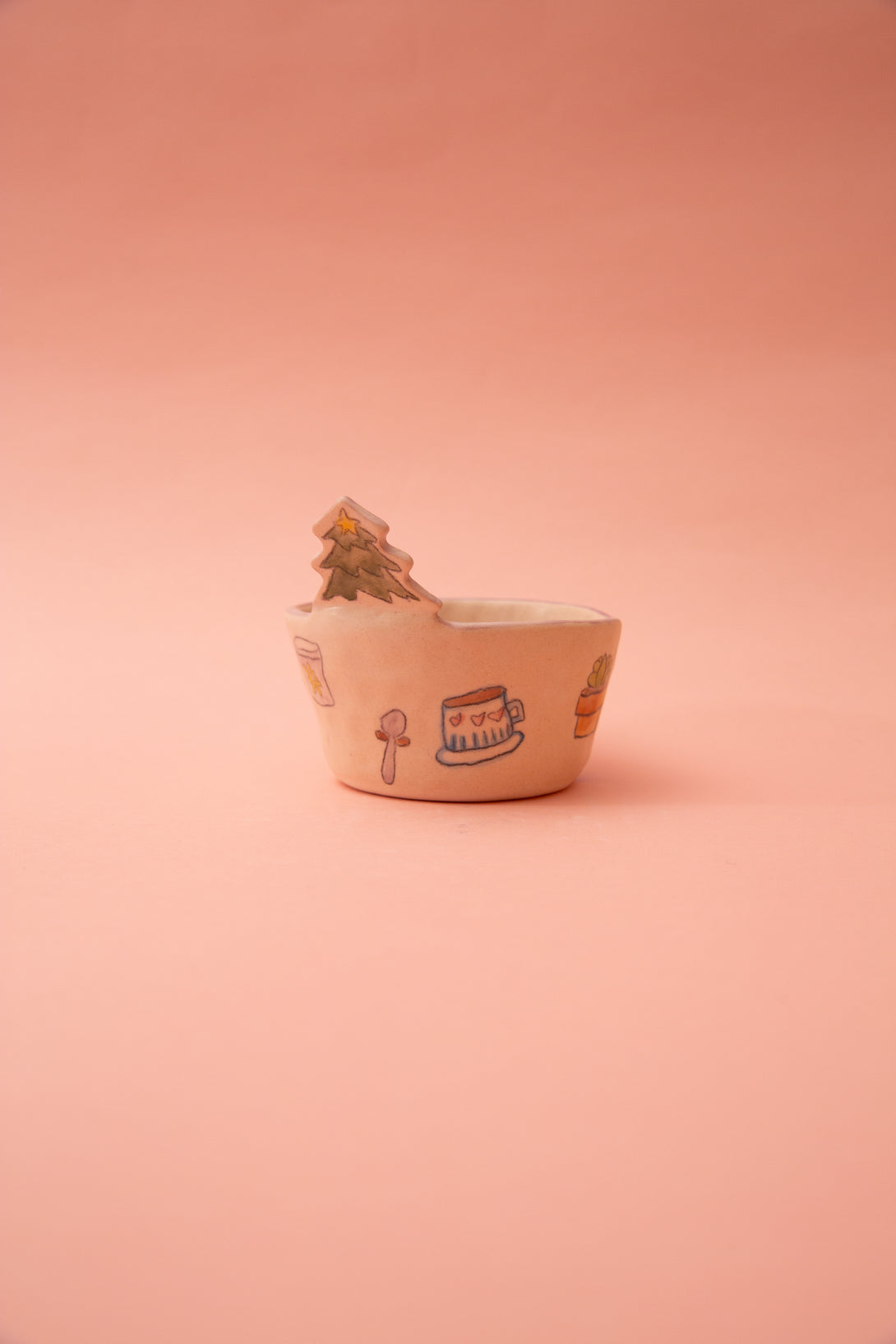 Small ceramic bowl with cartoon designs on a pink background