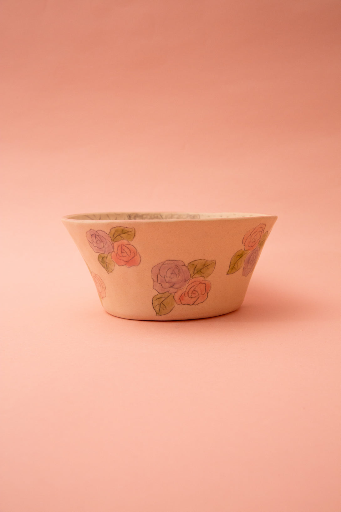 Ceramic bowl with floral design on a pink background