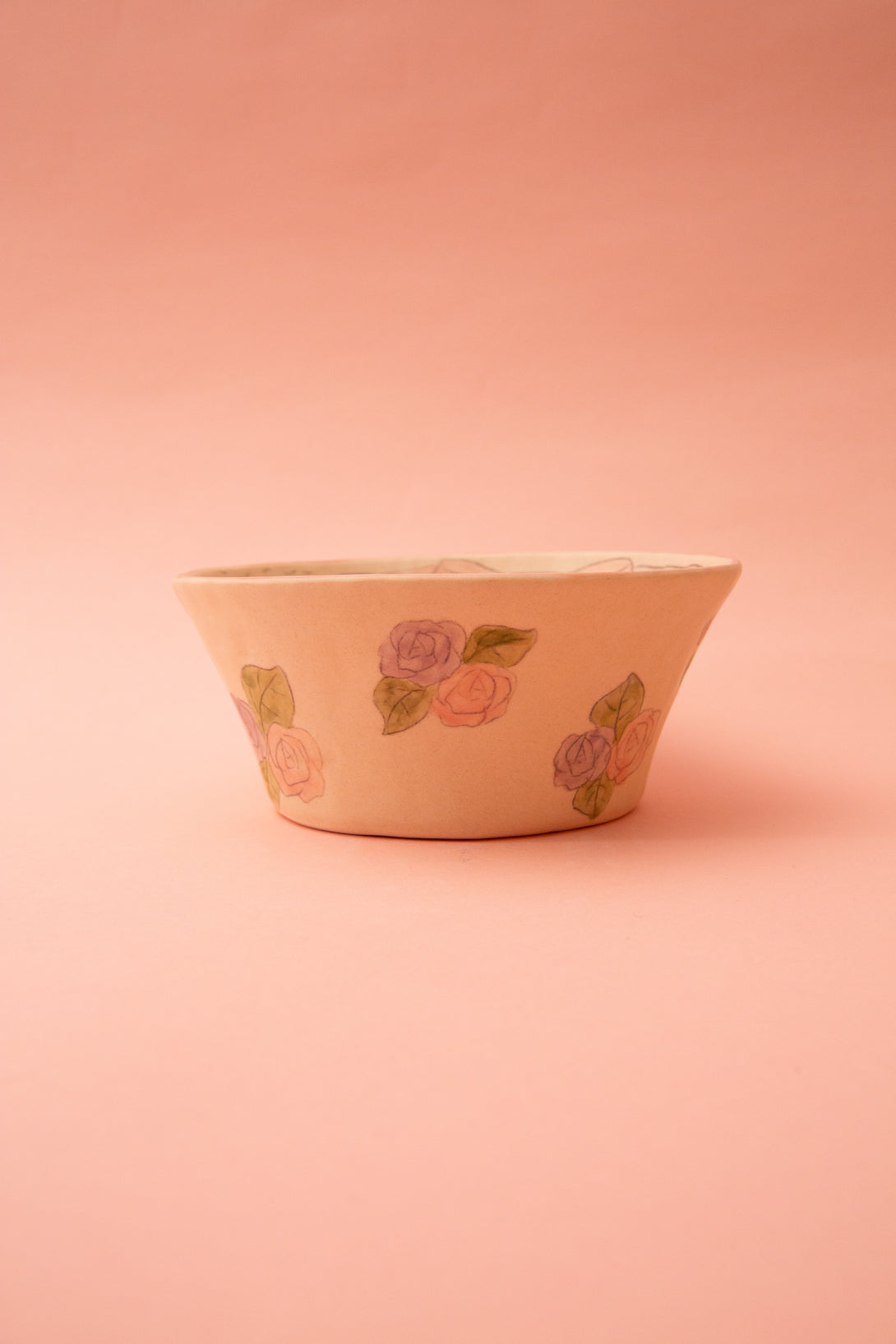 Ceramic bowl with floral design on a pink background