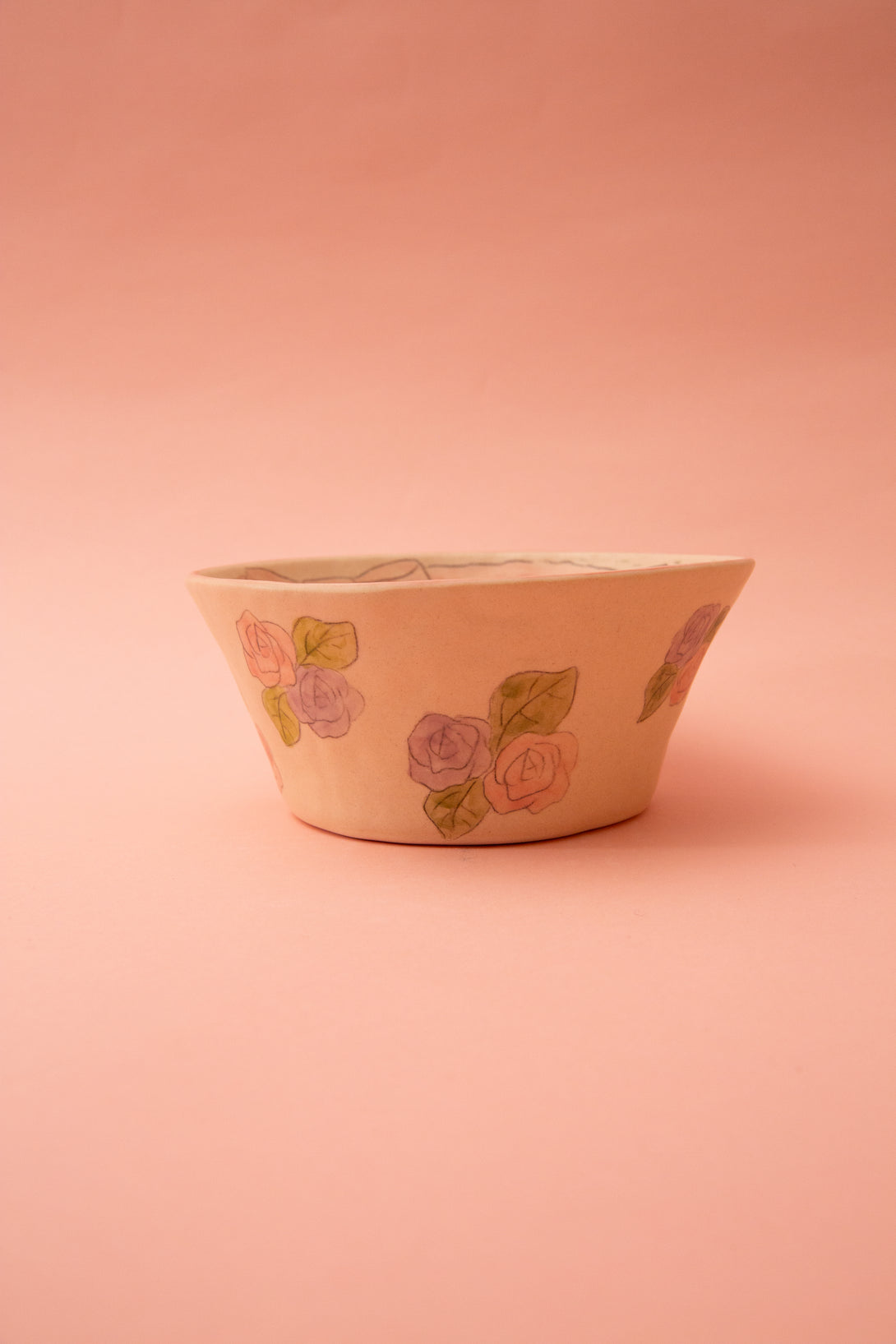 Ceramic bowl with floral design on a pink background
