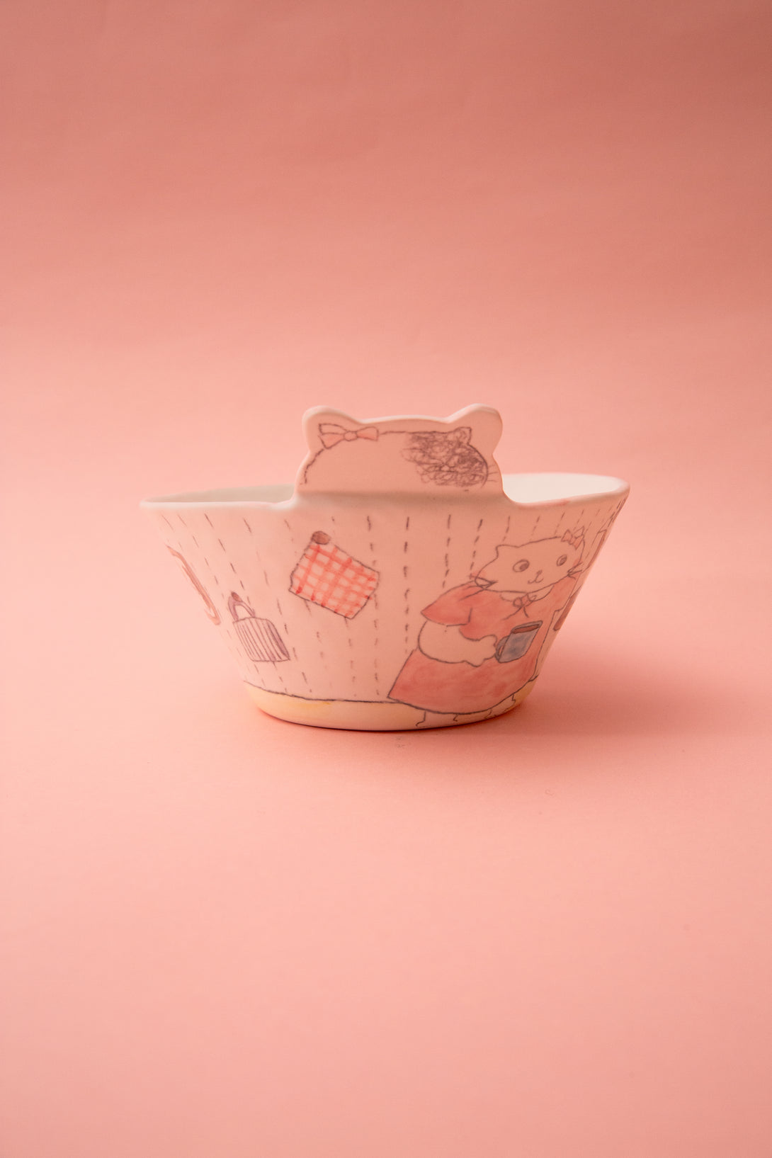 Ceramic bowl with cat design on a pink background