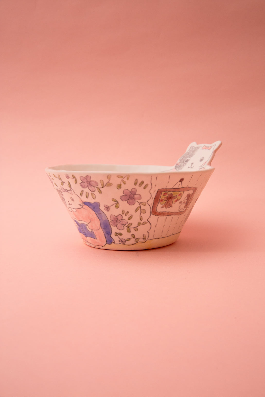 Ceramic bowl with floral and geometric patterns on a pink background