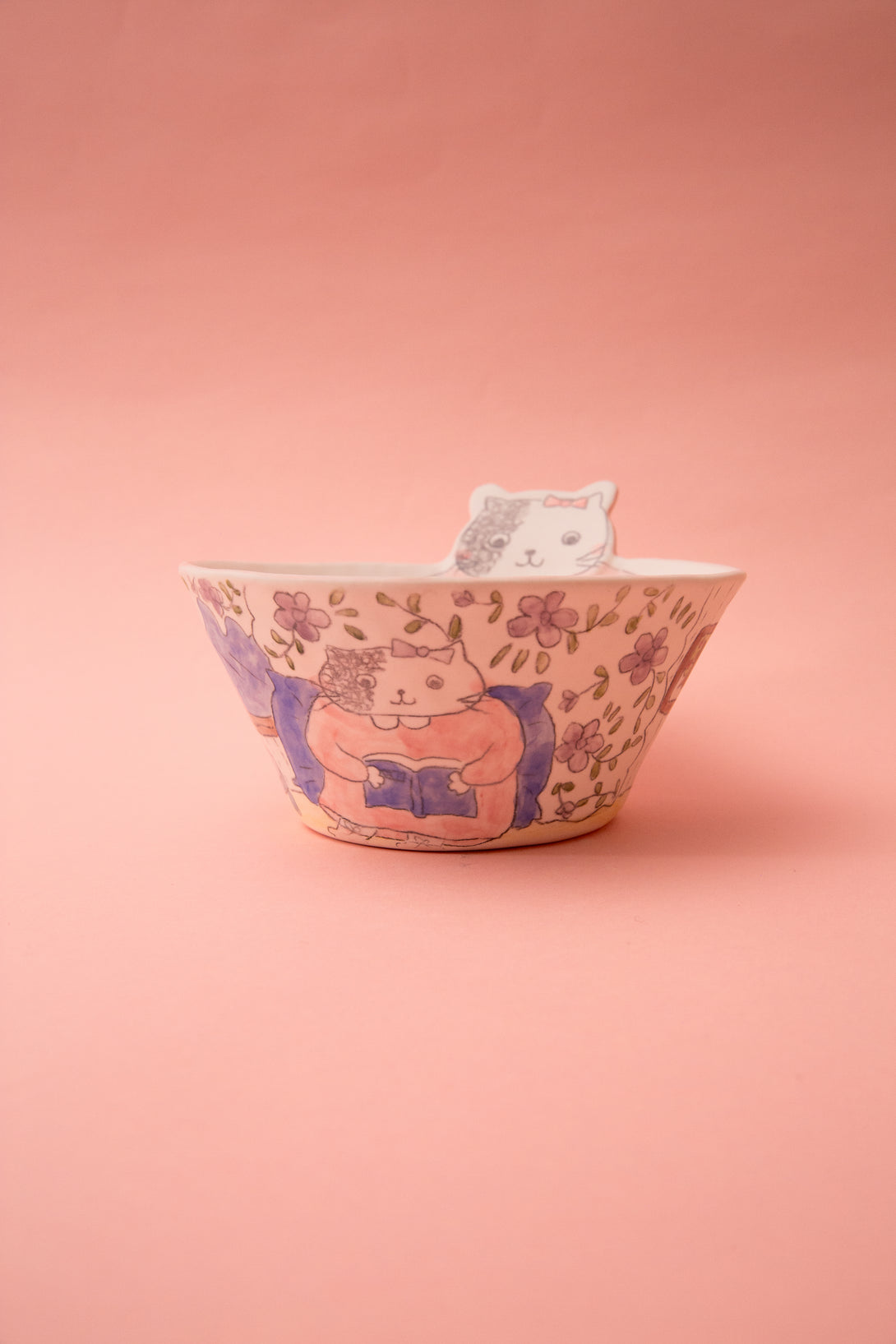 Ceramic bowl with cat design on a pink background