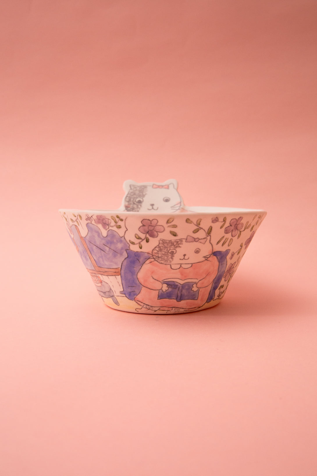 Ceramic bowl with cat design on a pink background