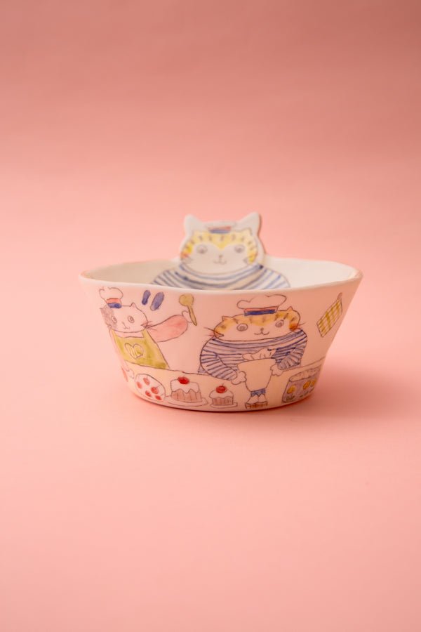 Ceramic bowl with cat illustrations on a pink background