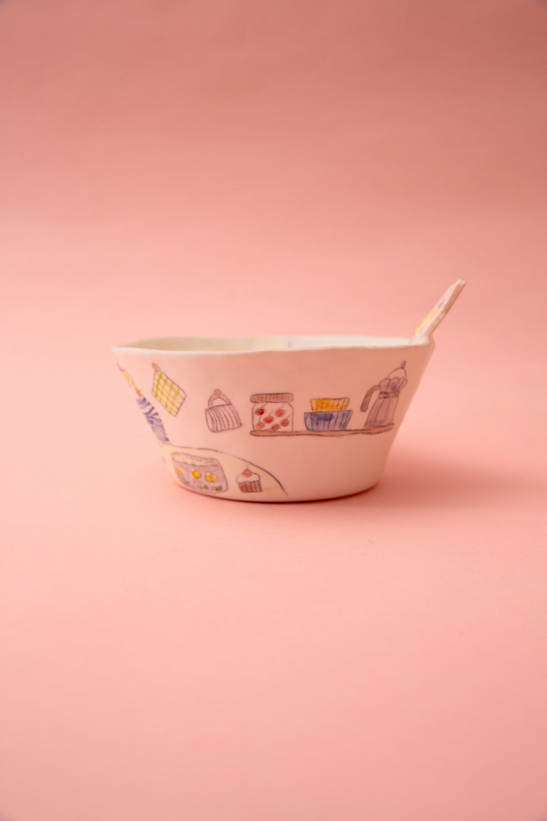 White bowl with colorful designs on a pink background