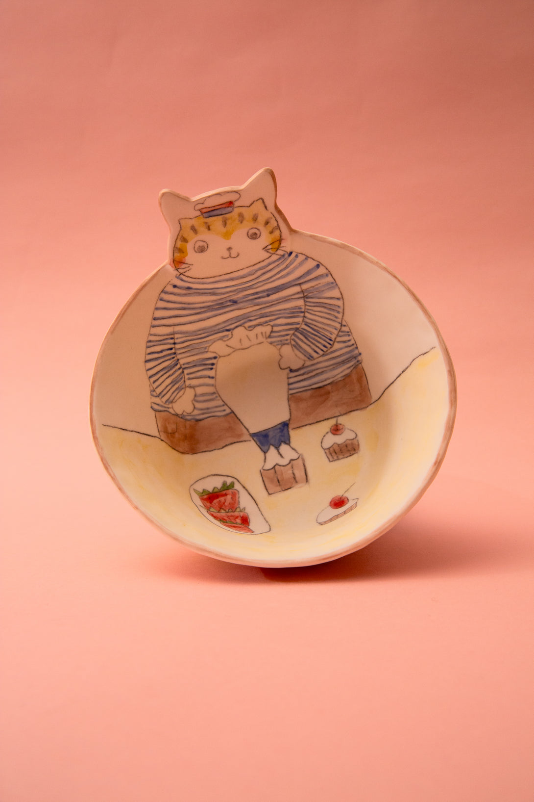 Ceramic bowl with a cat illustration on a pink background