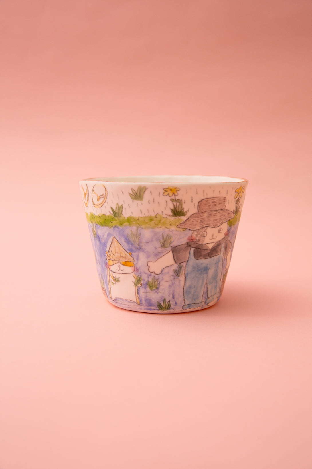 Ceramic mug with a colorful design on a pink background