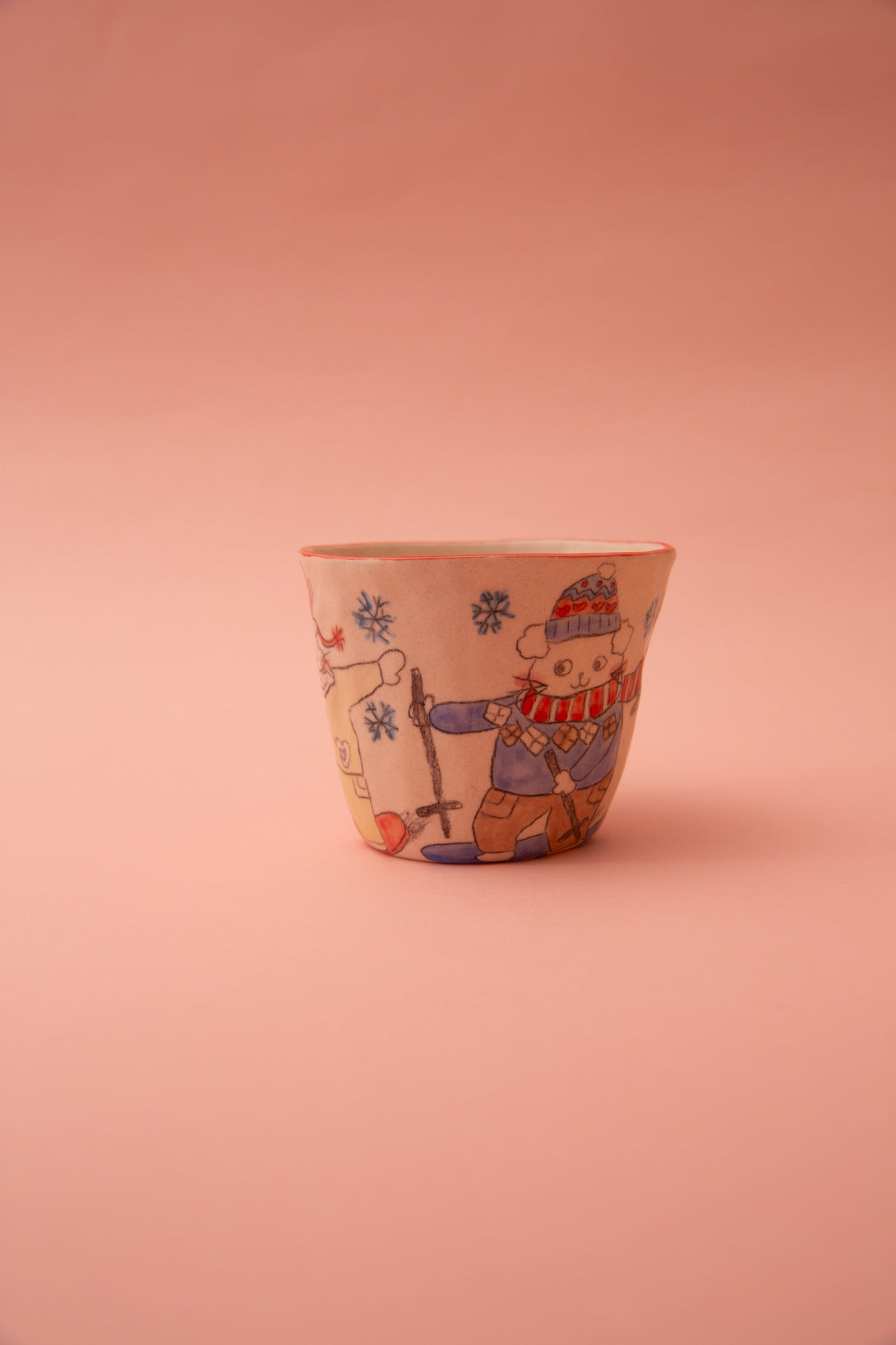 Ceramic cup with a decorative design on a pink background