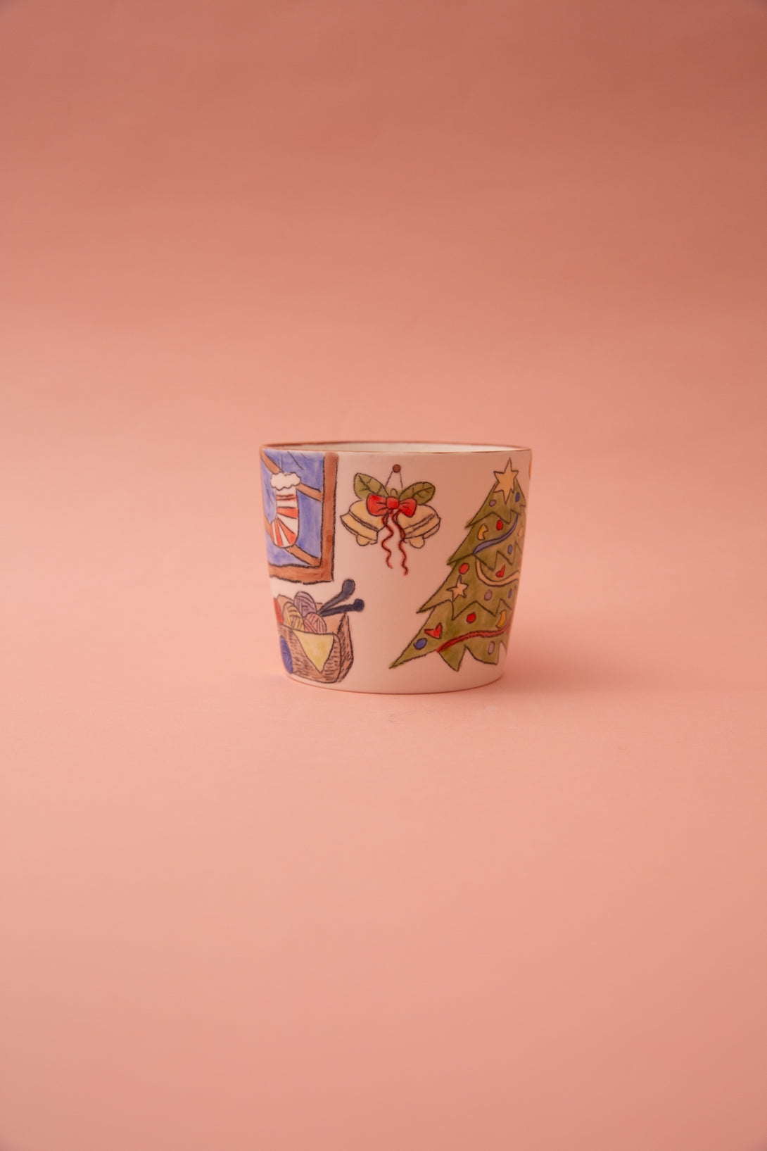 Ceramic mug with colorful illustrations on a pink background