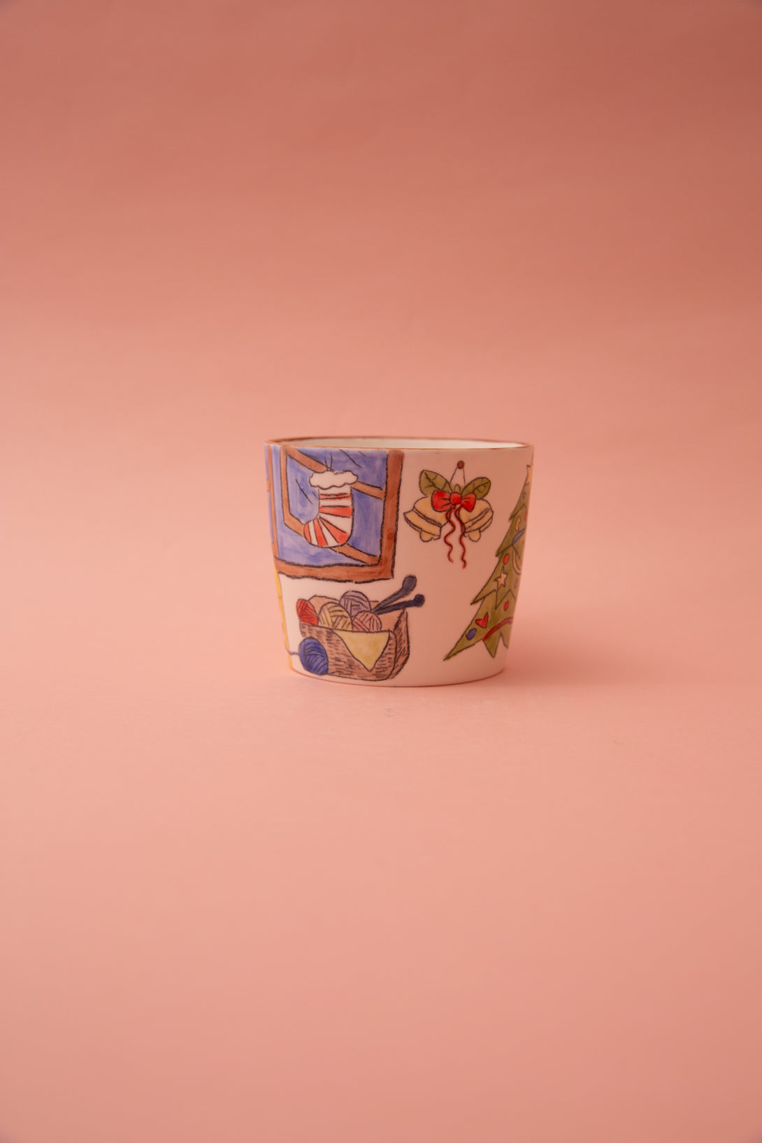 Ceramic mug with colorful illustrations on a pink background