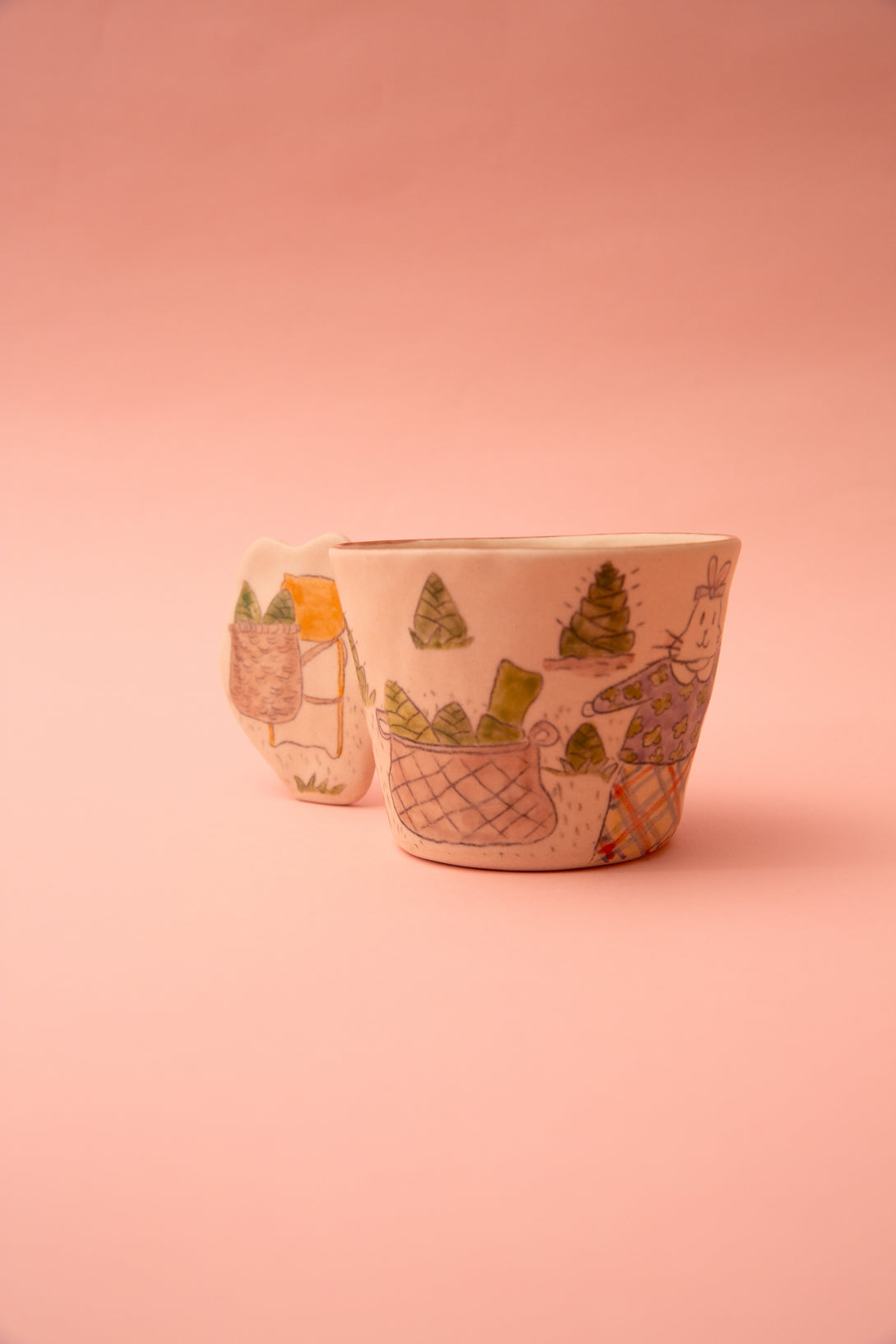 Ceramic cup with artistic designs on a pink background