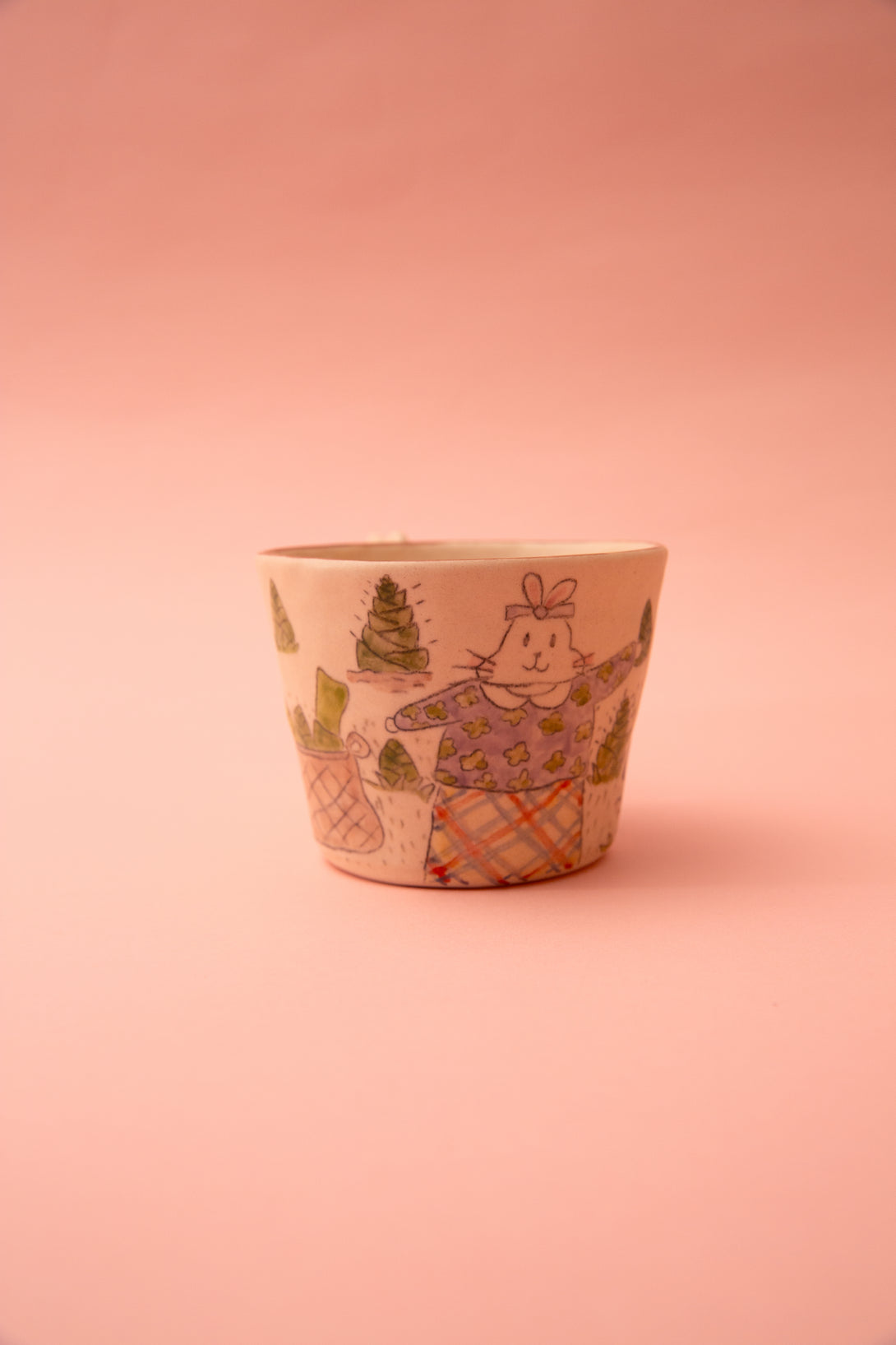 Ceramic cup with a decorative design on a pink background