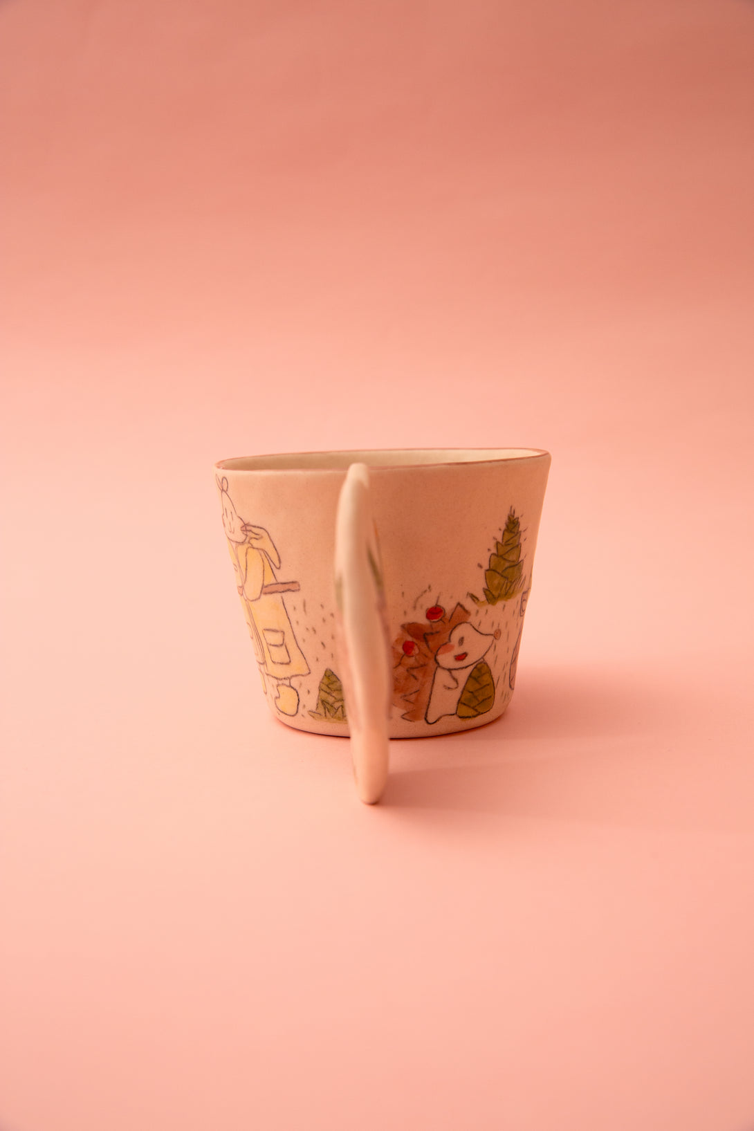 Ceramic cup with cartoon design on a pink background