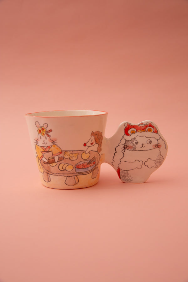 A ceramic mug with animal illustrations and a fun handle on a pink background