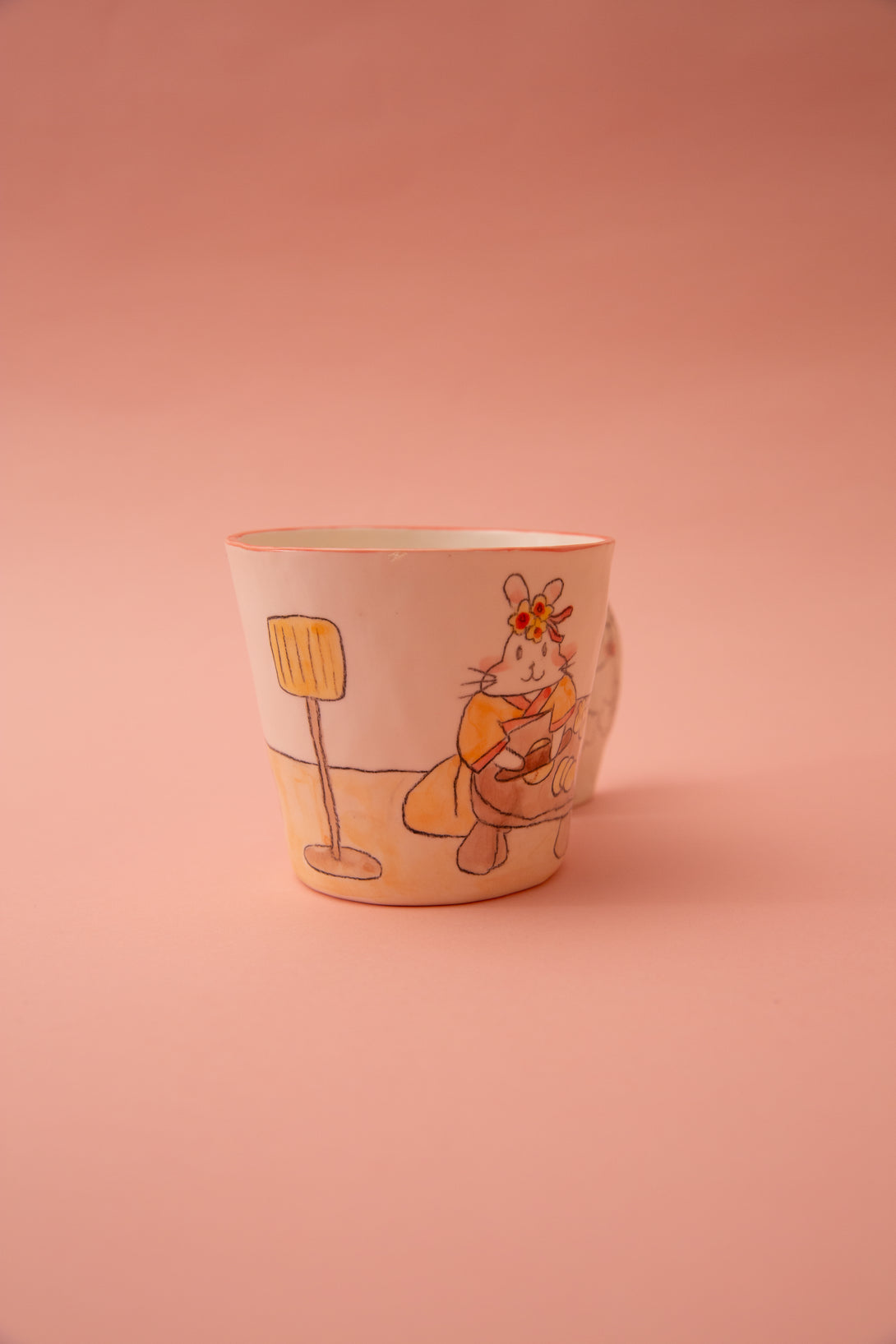 Ceramic cup with a cartoon character on a pink background