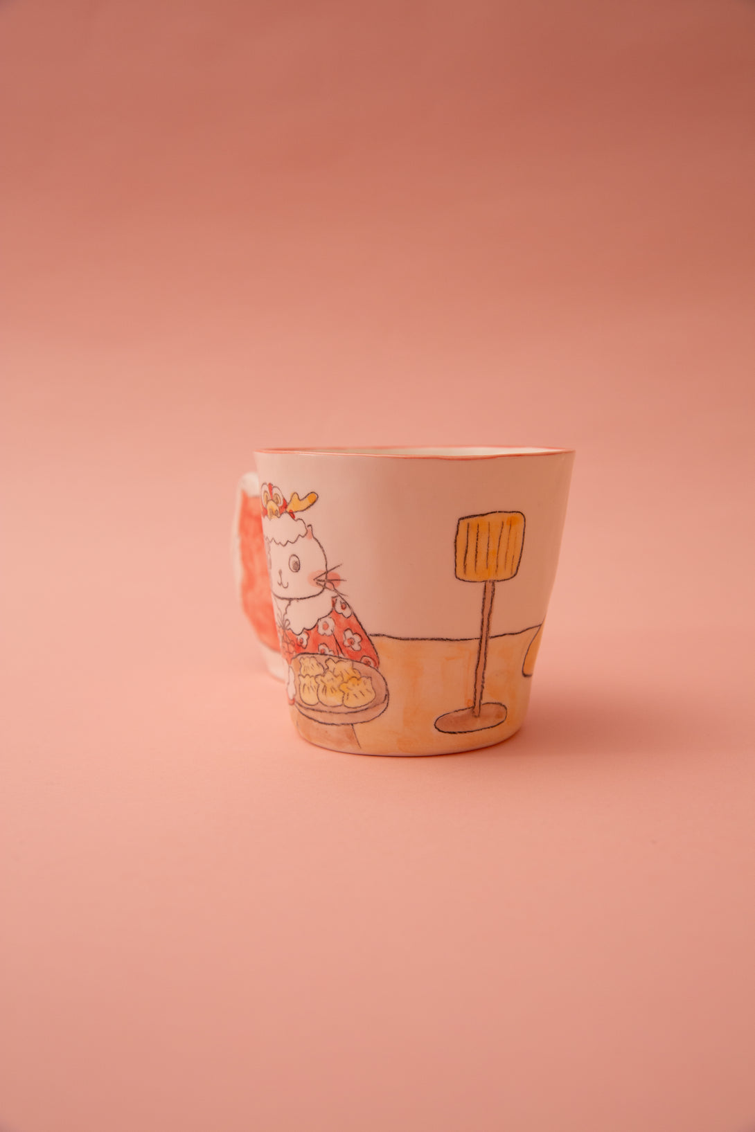 Ceramic cup with cartoon design on a pink background