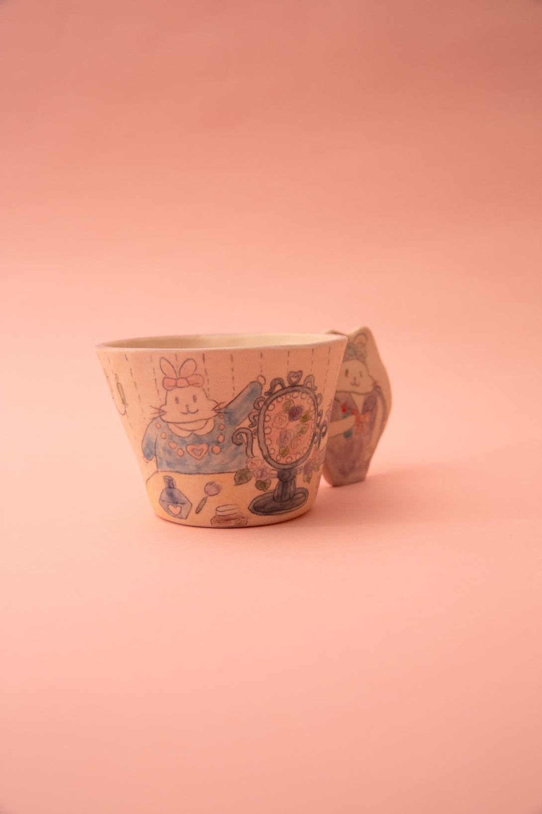 Ceramic mug with a design on a pink background