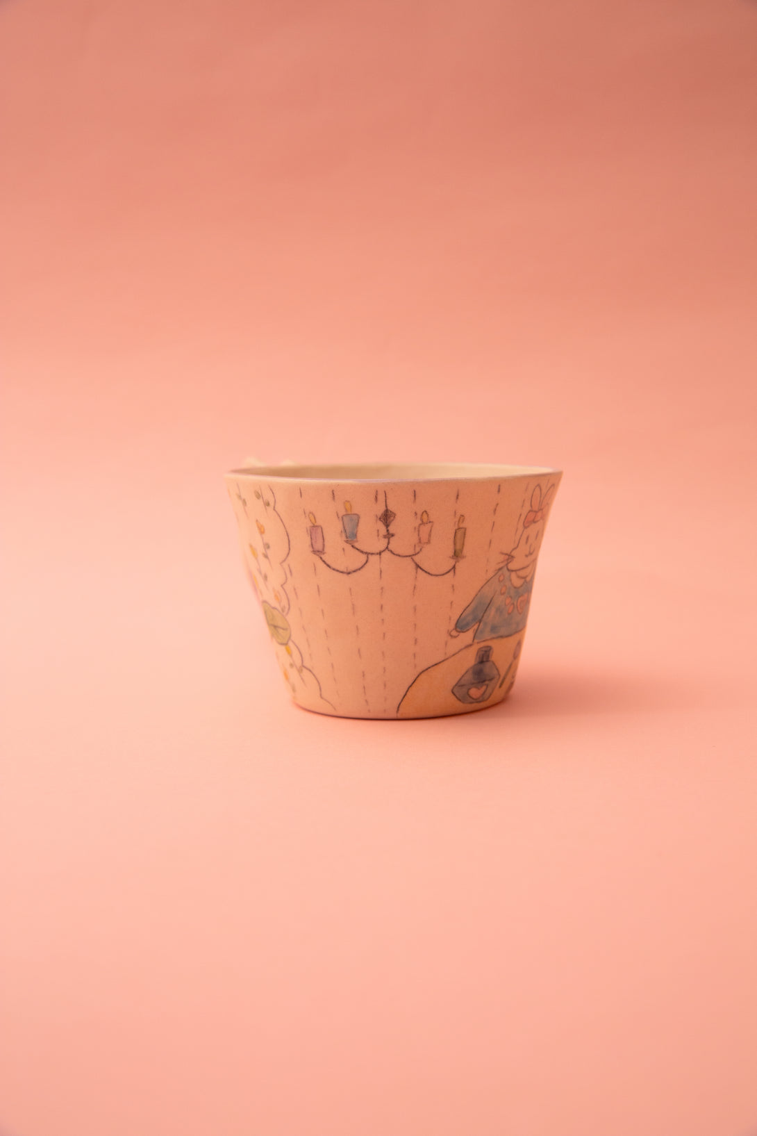 Ceramic cup with artistic design on a pink background