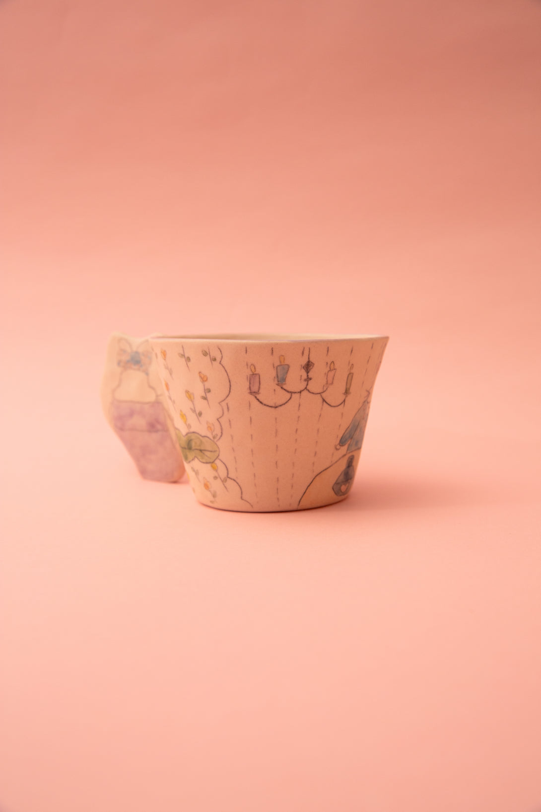 Ceramic cup with floral pattern on a pink background