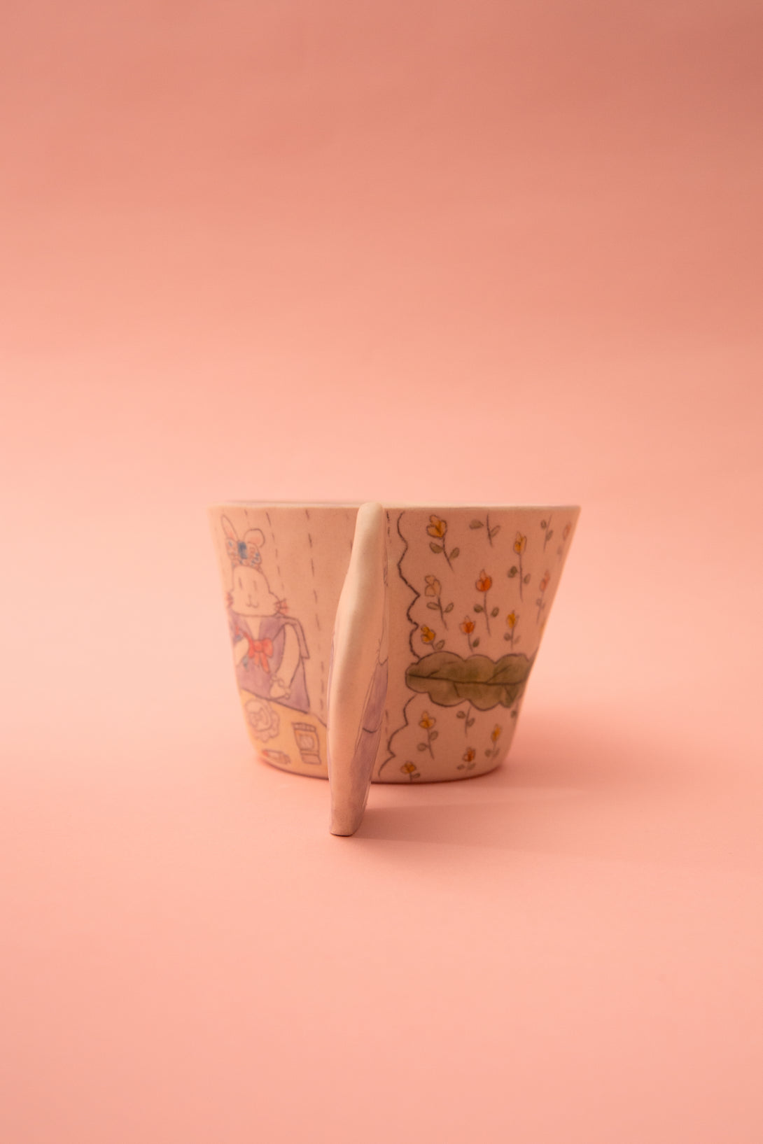 A mug with floral patterns on a pink background