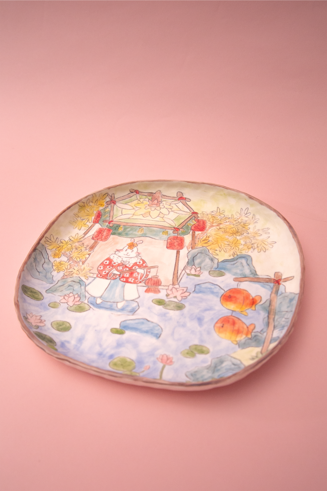 Plate with a scenic design on a pink background