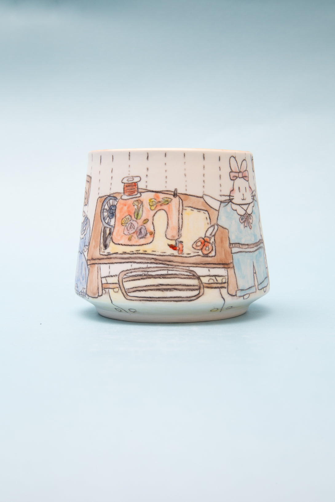 Ceramic mug with a handpainted design on a light blue background