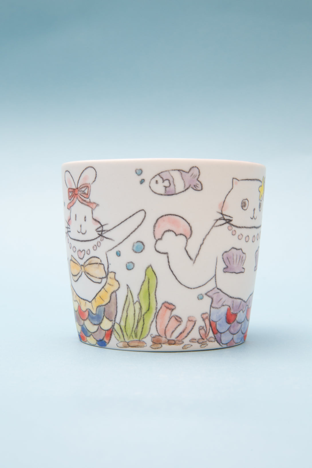 Ceramic mug with cartoon designs on a light blue background