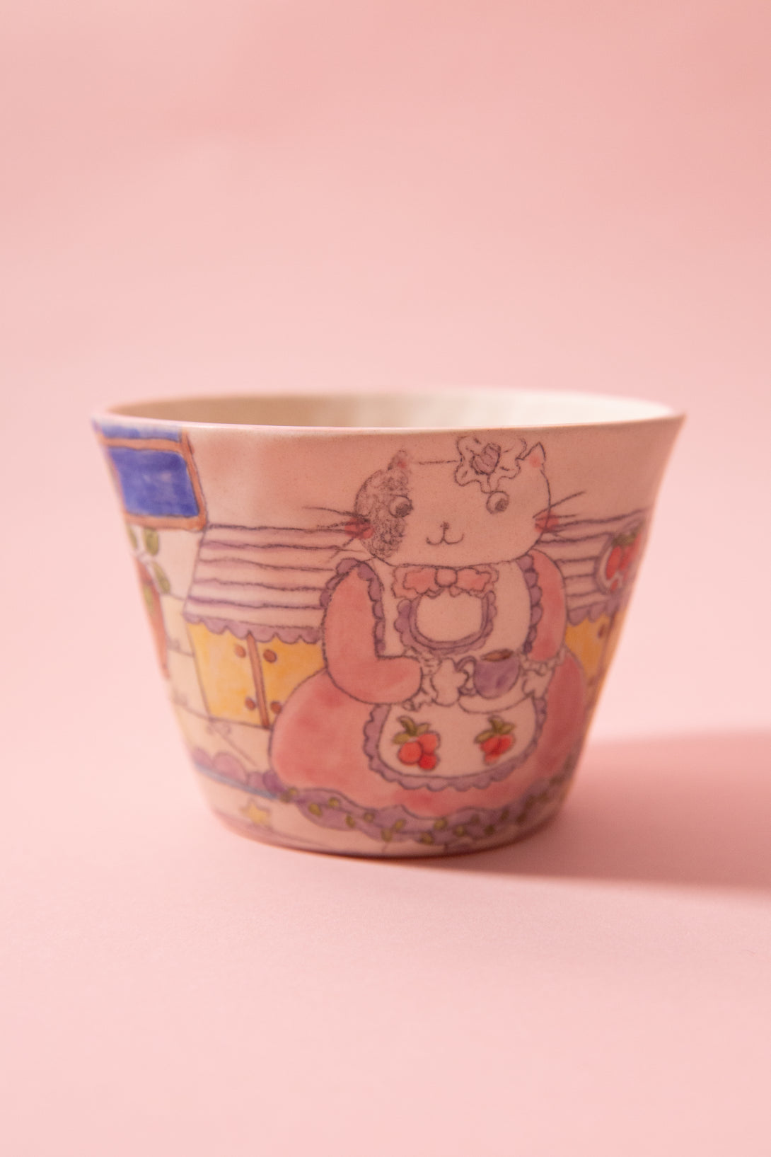 Ceramic cup with cat design on a pink background