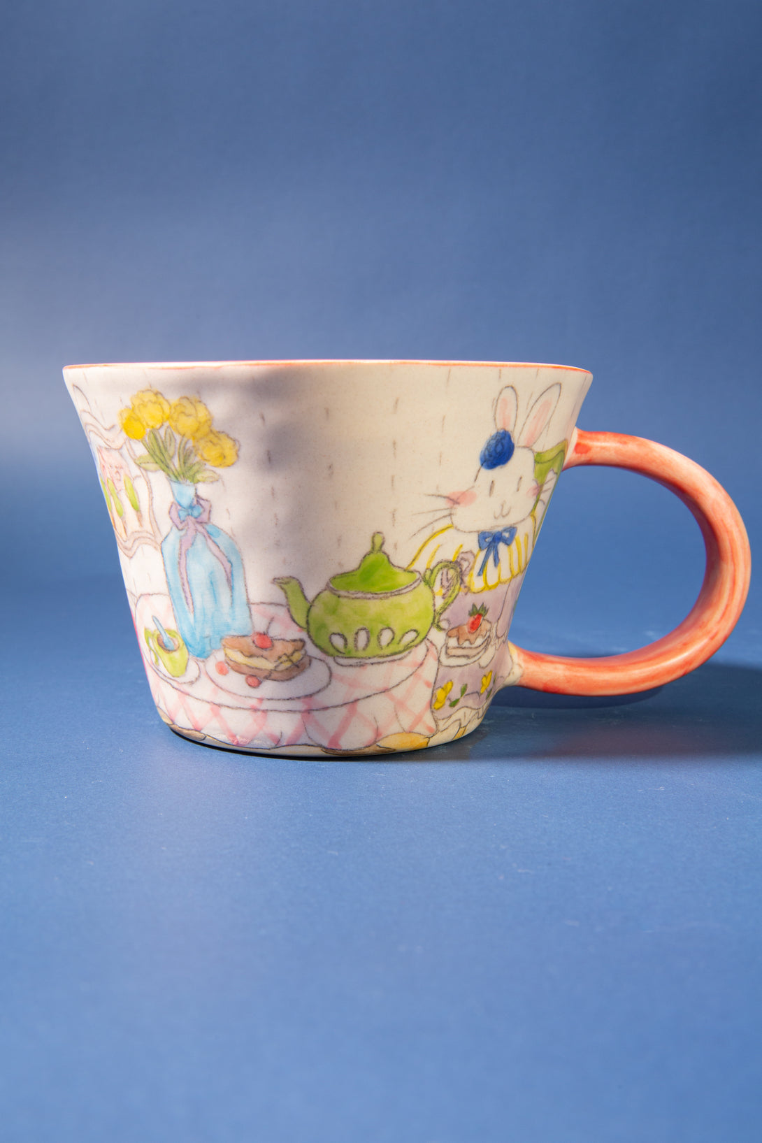 Ceramic mug with colorful illustrations on a blue background