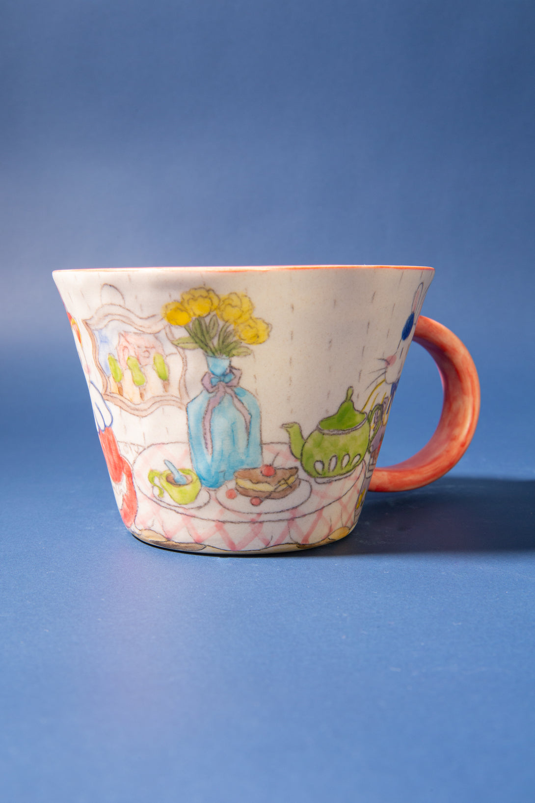 Ceramic mug with colorful illustrations on a blue background