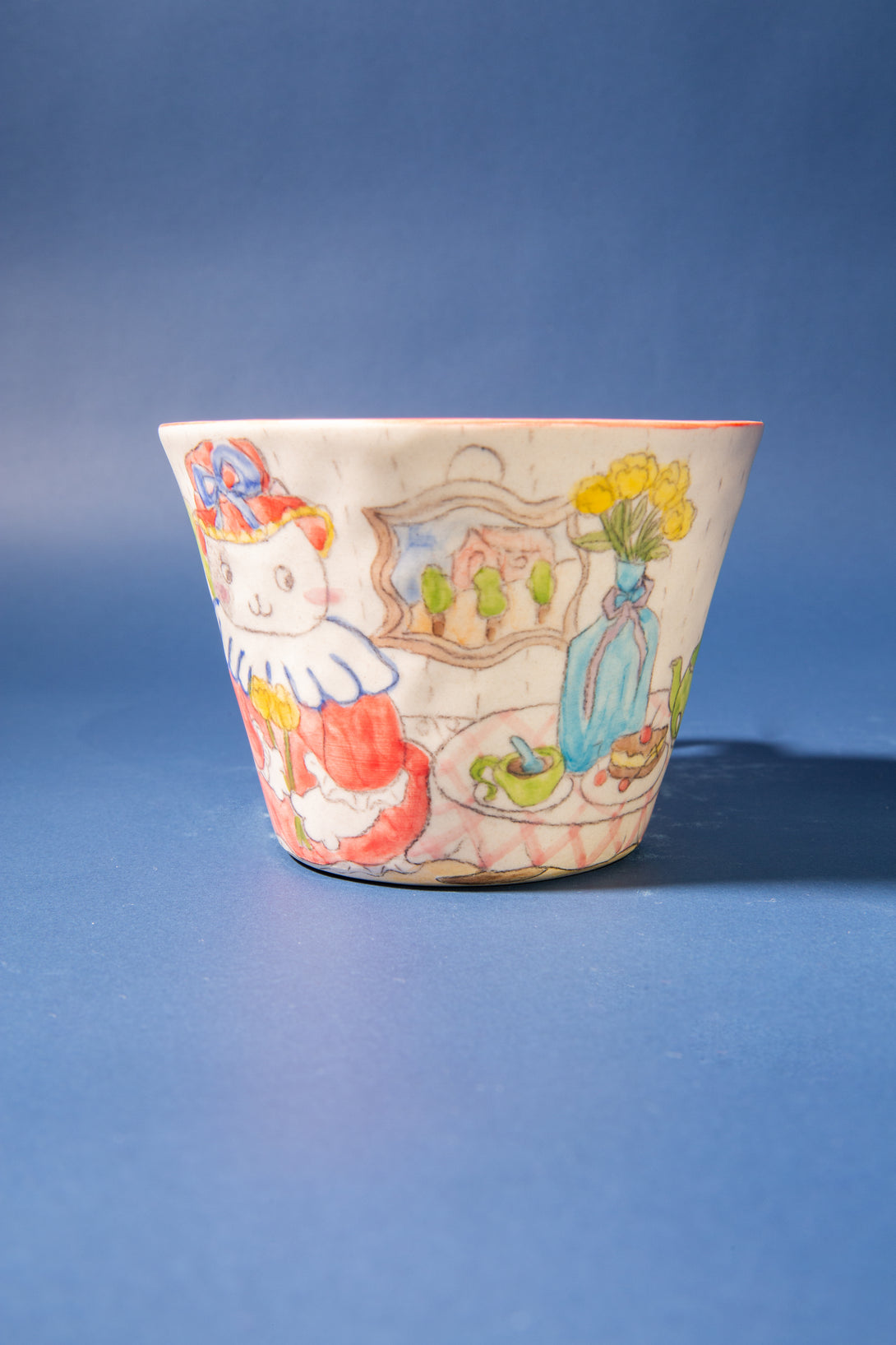 Ceramic cup with colorful illustrations on a blue background