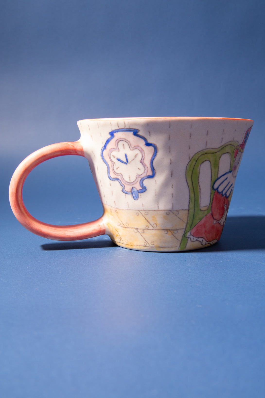 Ceramic mug with colorful designs on a blue background