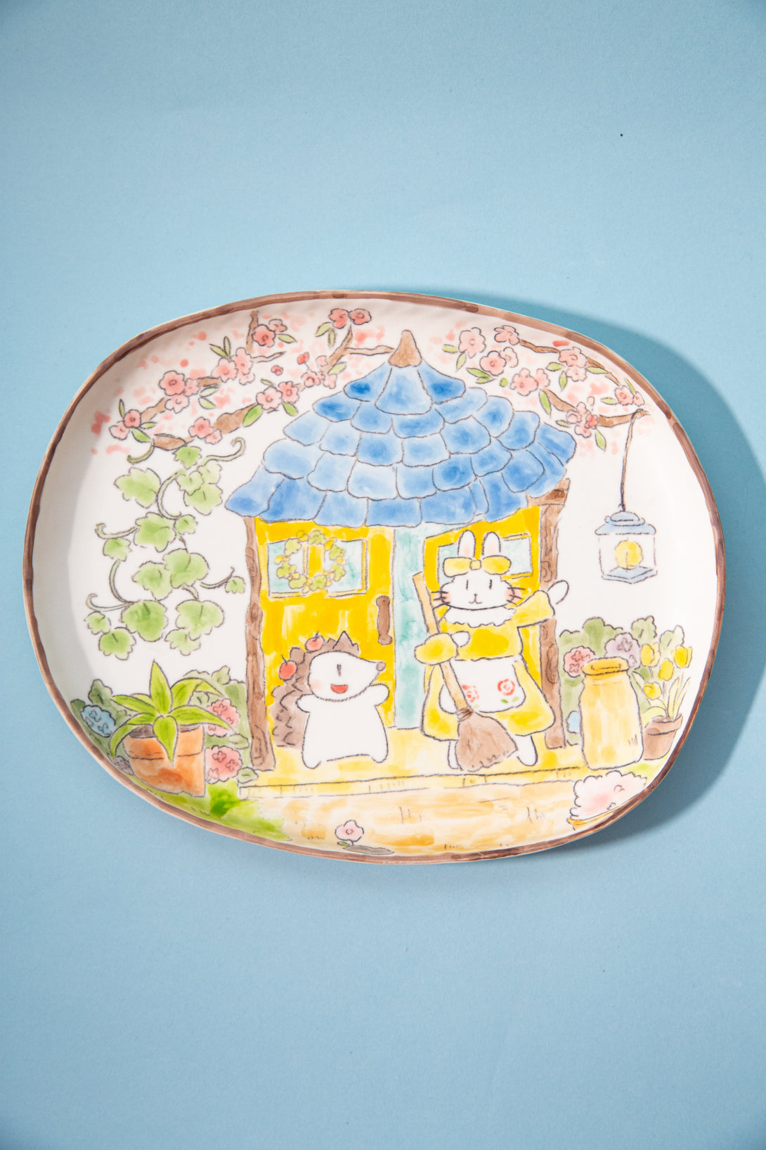 plate with cartoon characters and a garden scene on a light blue background