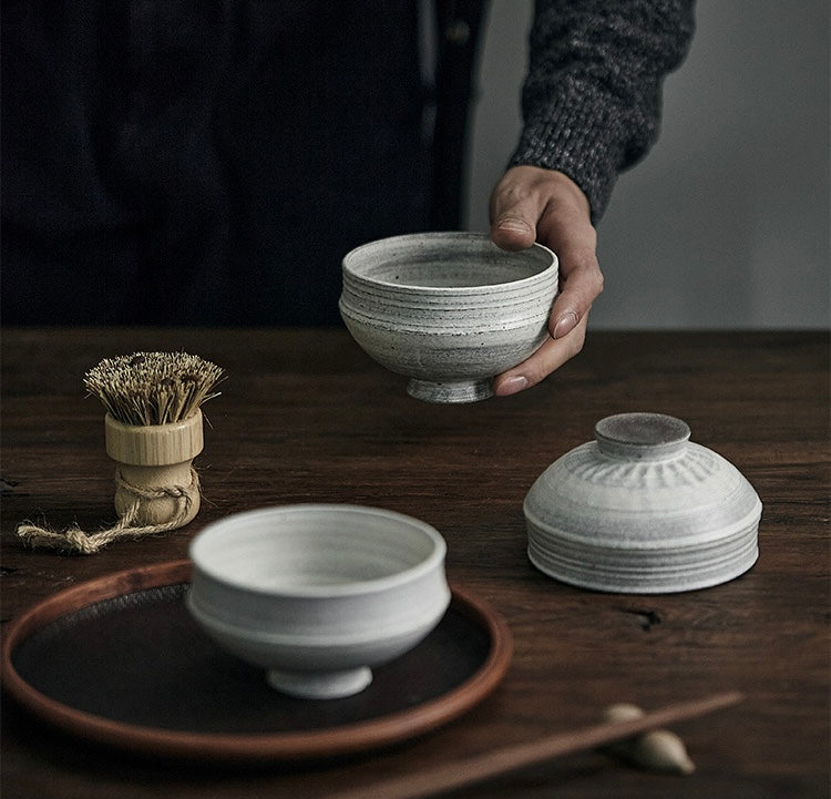 gray and white ceramic bowls with a simple design on a wooden table
