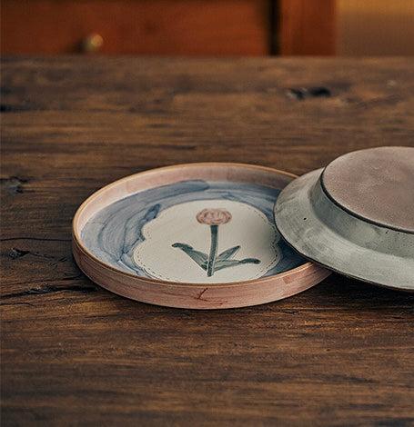 Ceramic plate in floral patterns, primarily in blue and pink colors.