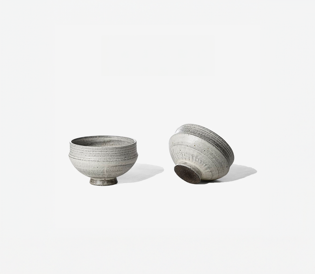 Two gray ceramic bowls with a simple design on a white background.