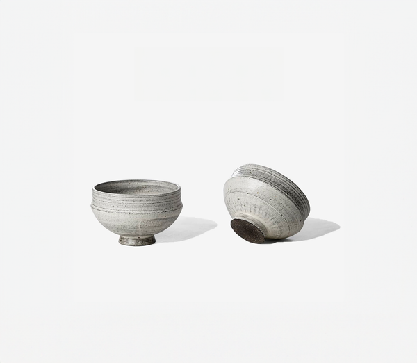 Two gray ceramic bowls with a simple design on a white background.