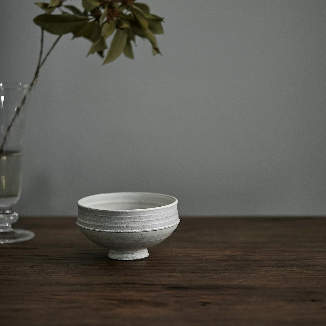  ceramic white bowl with a simple design on a wooden table