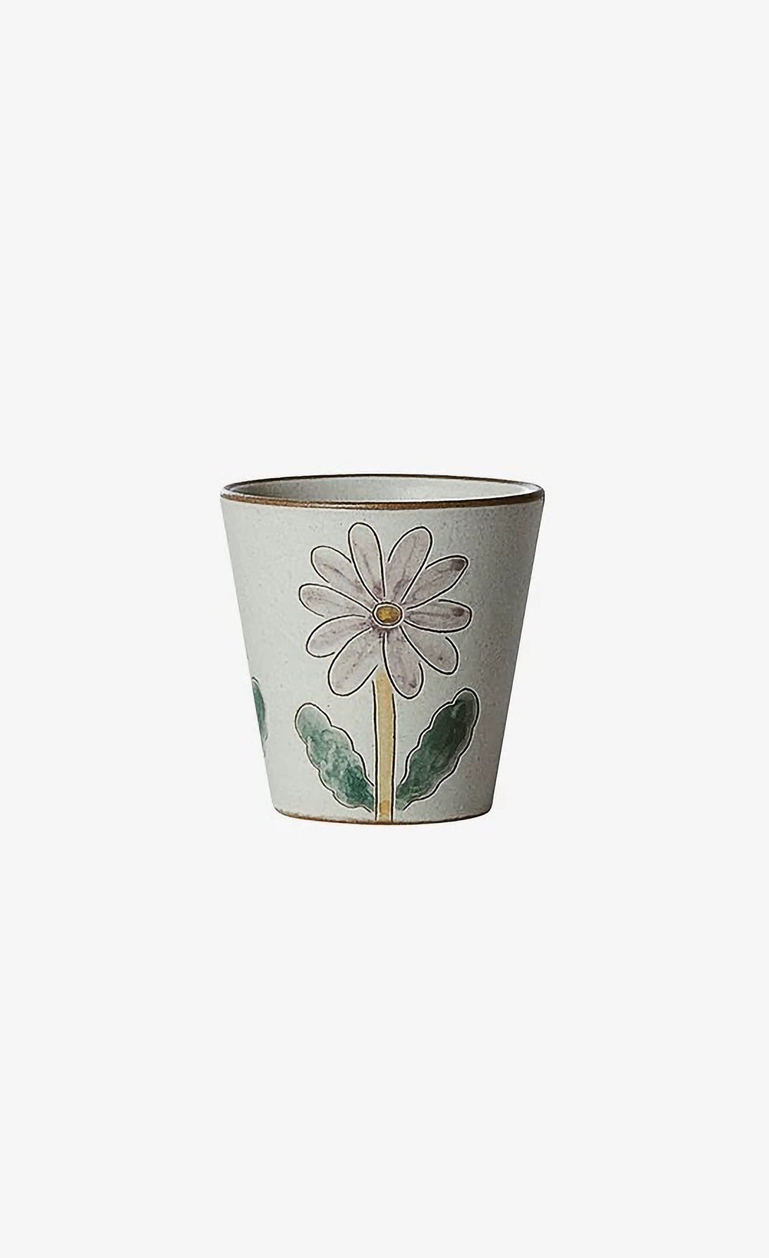 A ceramic cup with a floral pattern, featuring a large daisy flower in the center and leaves in the background.
