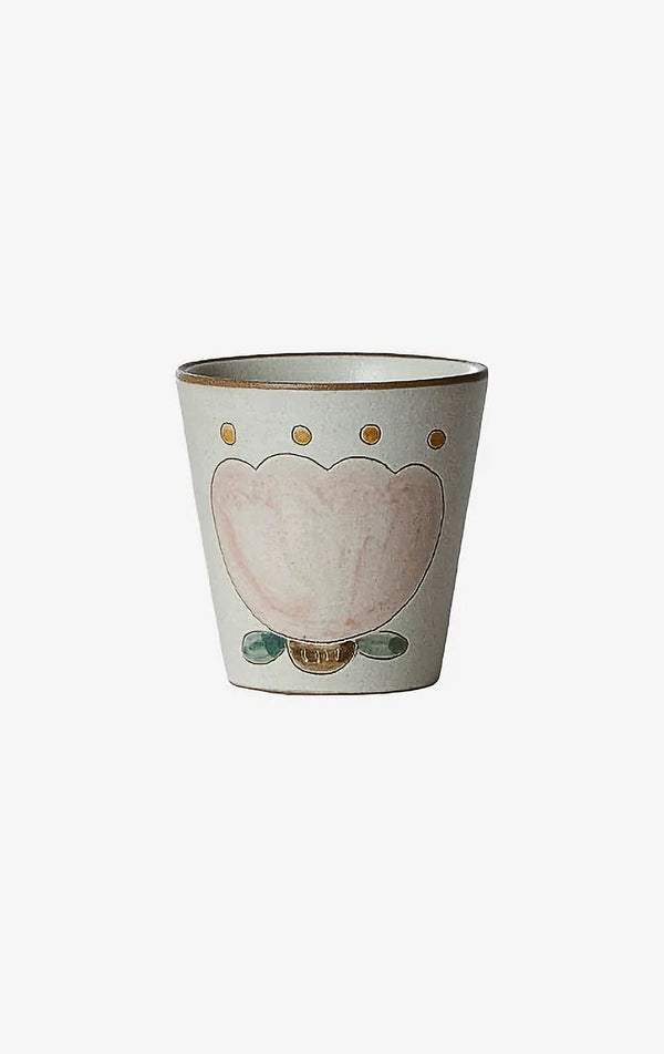 A beige ceramic cup with a floral tulip pattern in the center.