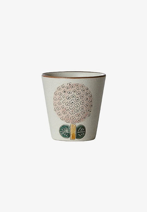 A beige ceramic cup with a floral spiral pattern design