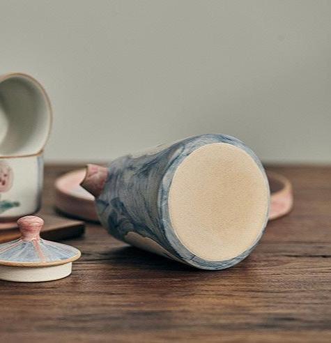 ceramic teapot and tray in floral patterns, primarily in blue and pink colors.