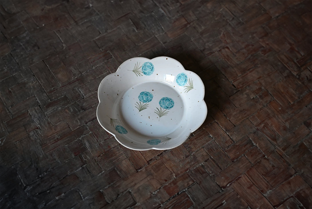 white ceramic plate with blue floral patterns in the center.