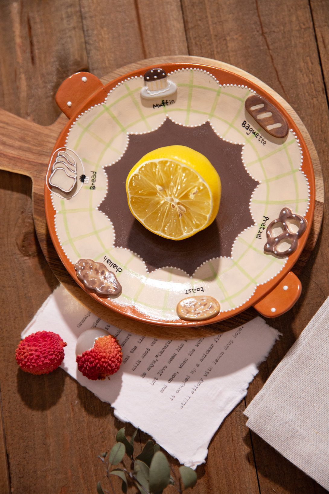 ceramic serving plate with a lemon and small fruits on a wooden surface
