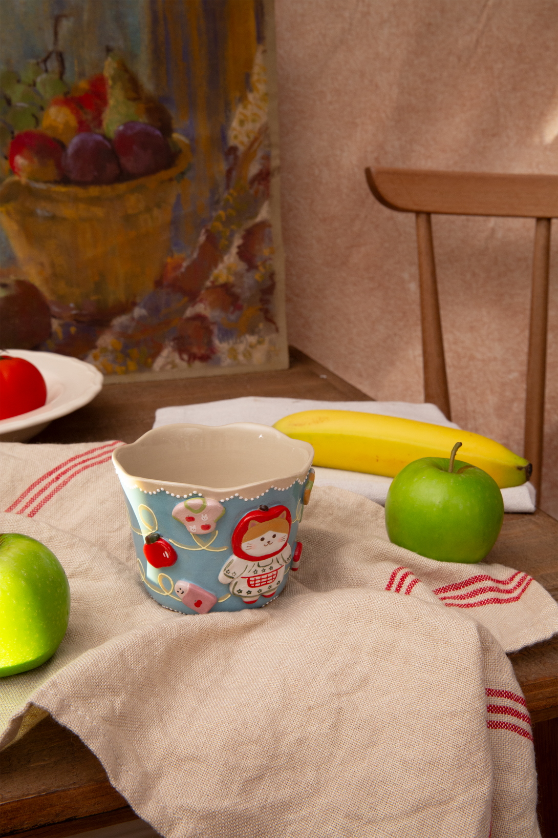 Cup with cartoon design on a tablecloth with apples and bananas