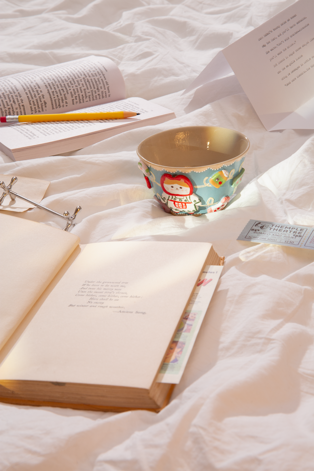 Open book with a ceramic cup on a white textured surface