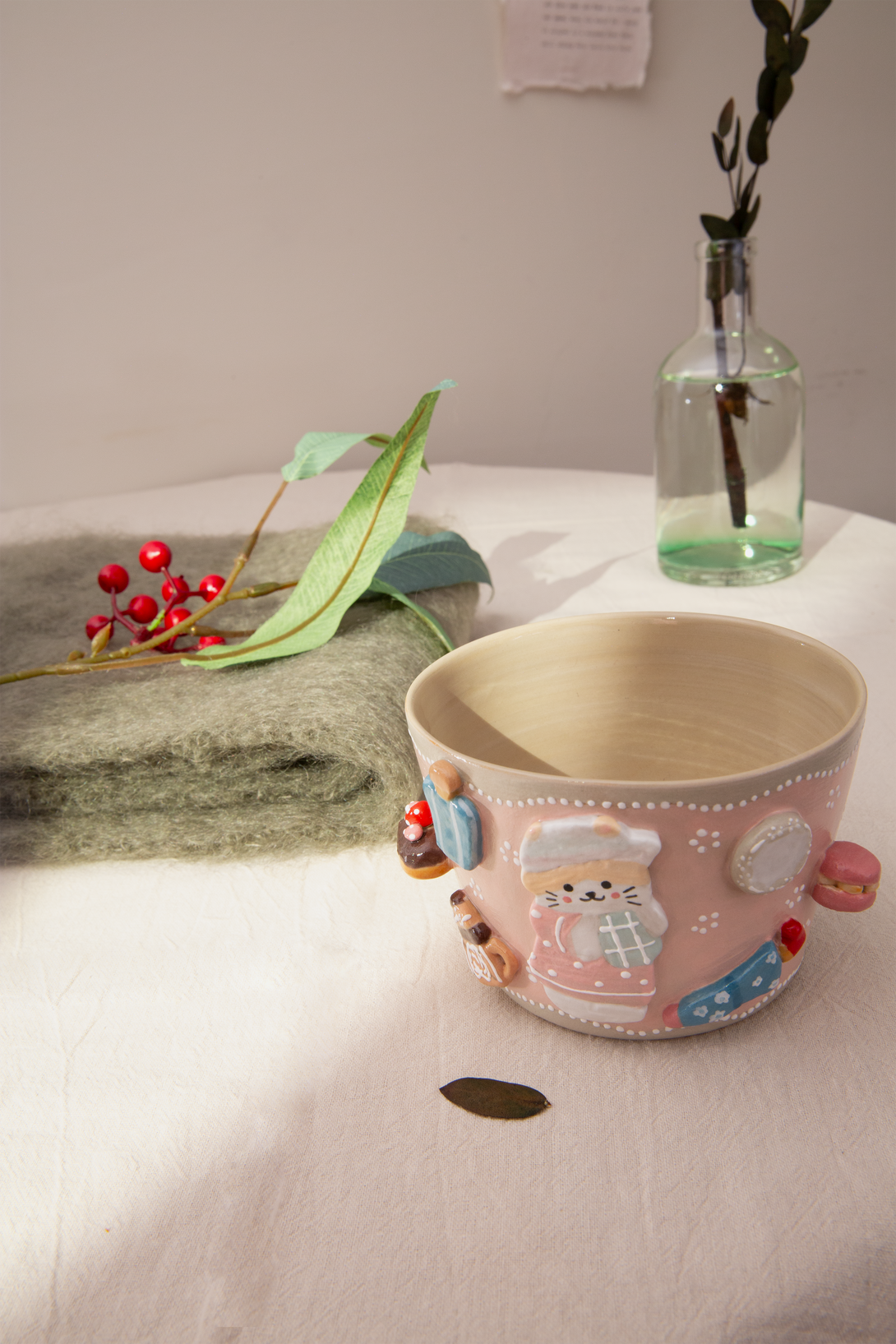 Pink ceramic mug with cartoon character design on a white surface