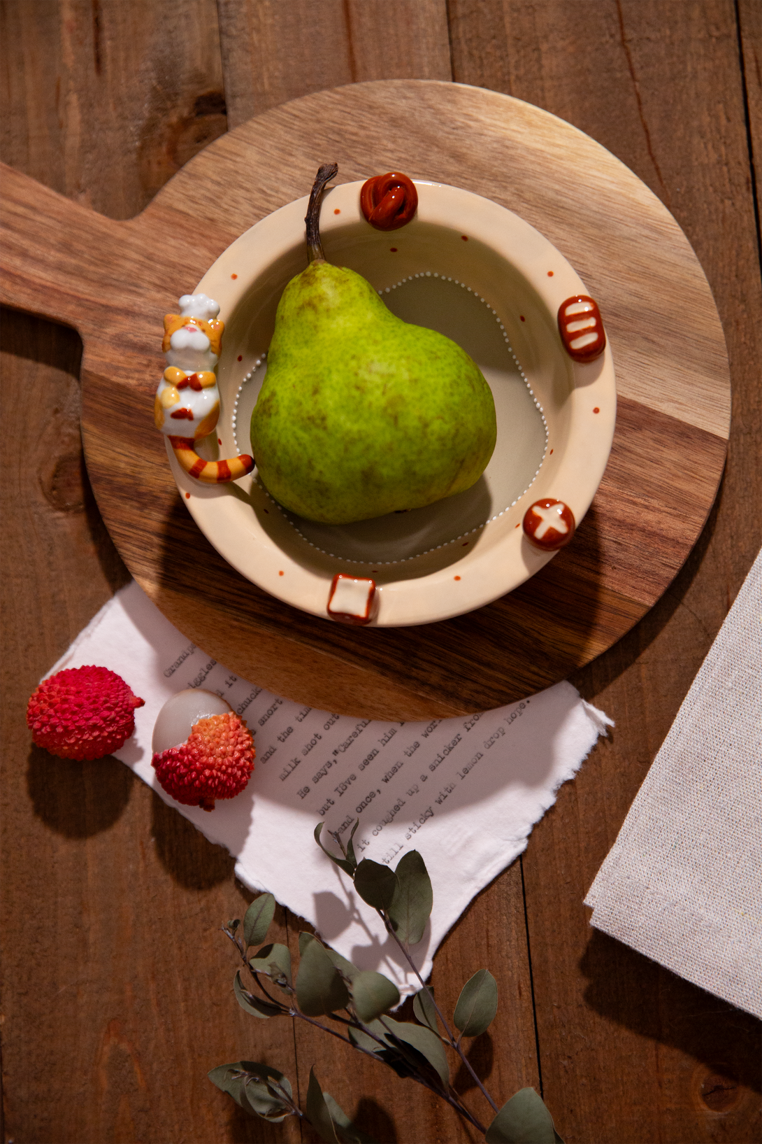 Green pear in a ceramic bowl with red berries on a wooden surface