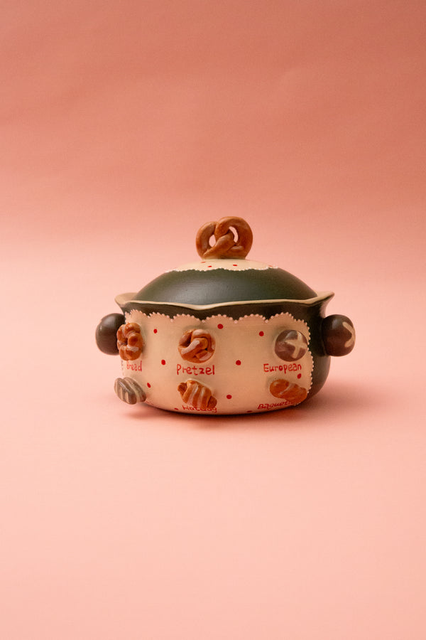 Ceramic bowl with a lid on a pink background